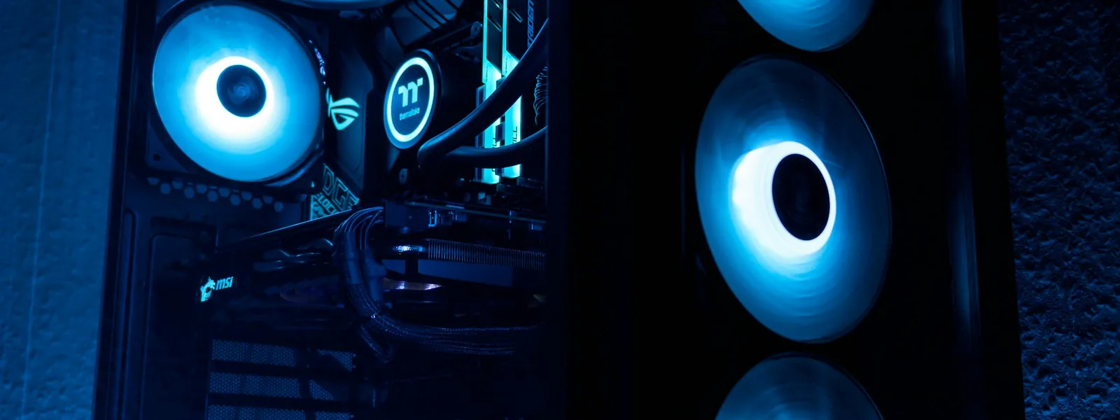 Gaming computer with blue fan lighting behind the glass of the case